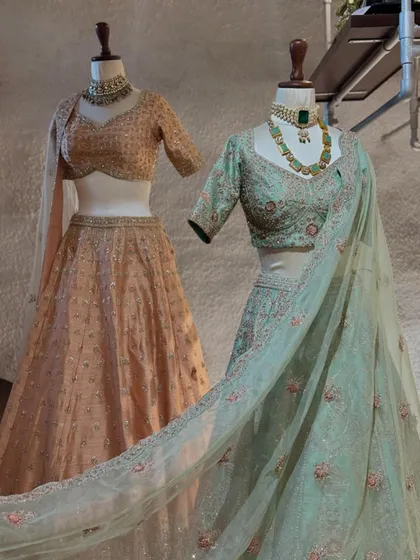 This image displays two beautiful lehengas in pastel peach and mint green. Both feature delicate embroidery, offering a soft and romantic option for wedding festivities.