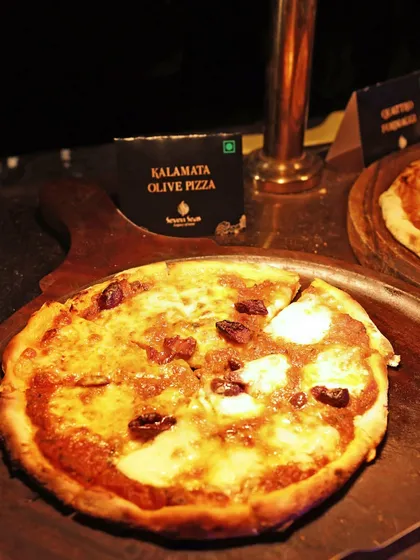 A gourmet Kalamata Olive Pizza, fresh from the oven. Our pizzas feature high-quality ingredients and creative toppings for a superior taste experience.