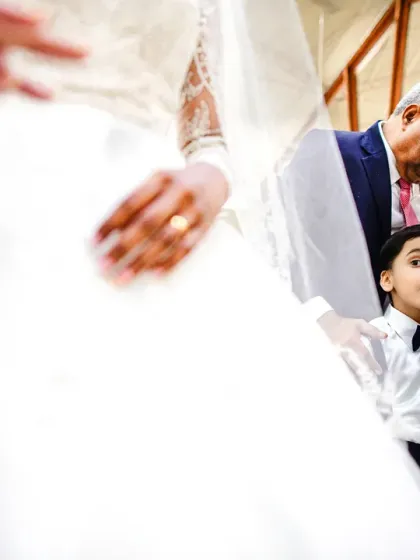A young page boy looks up in awe at the bride. The wonder in his eyes is a beautiful, candid moment.