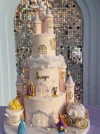 The cake is the centerpiece of any party. This stunning multi-tiered castle cake is a work of art, complete with Disney princesses, a carriage, and delicate sugar work.