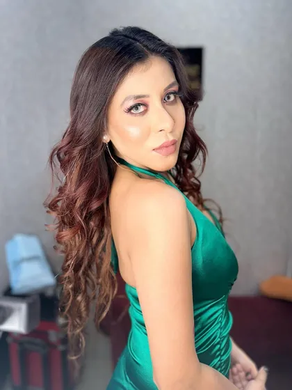 A side profile of the client in the green dress, showing off her glowing skin and the soft curls in her hair.