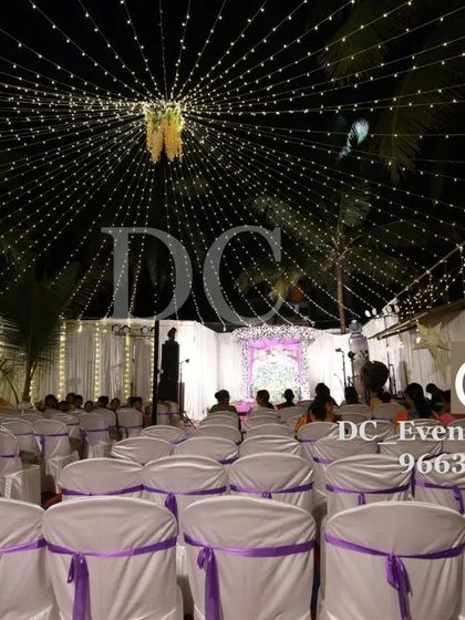 An outdoor event space illuminated by a canopy of string lights. This setup provides beautiful ambient lighting for guest seating areas.