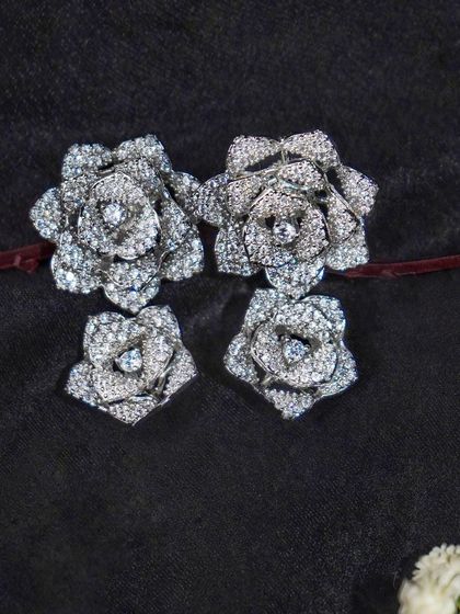 A set of large and small silver floral earrings on a dark background. This shot is useful for showing different sizes or a 'mommy and me' collection.