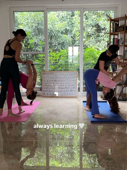 In our classes, learning is a constant process. Here, I'm providing hands-on adjustments to help students find more space and stability in their forward folds, ensuring they practice safely and effectively.