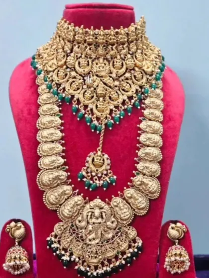 A South Indian temple jewellery set with a choker and a long haram, featuring goddess motifs and green bead accents.