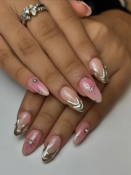 The full set of the celestial-inspired nails, combining pink ombré, silver chrome, and sparkly starbursts for a truly out-of-this-world design.