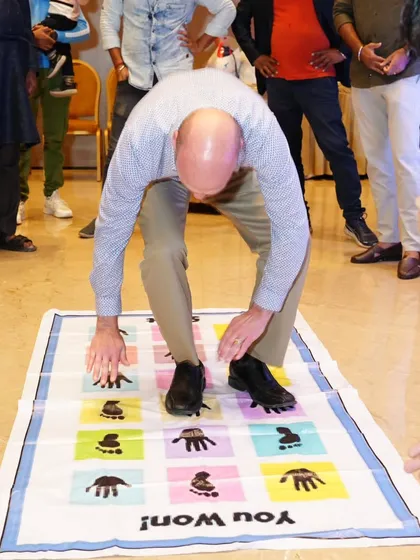 A participant gets tangled up in our fun mat game. It's a great photo opportunity and a hilarious moment for everyone watching.