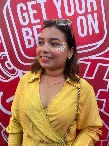 A beautiful leaf-like design in silver glitter on the cheekbone. It's an elegant and nature-inspired look.