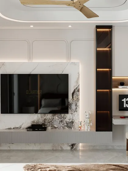 A master bedroom design for Apex D'Rio featuring custom circular wall paneling behind the bed. The opposite wall has a TV unit integrated with a workstation, all in a calming, neutral palette.