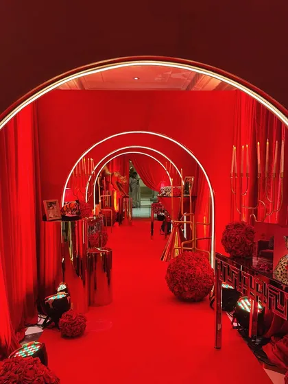 An entrance should be a statement. For this event, I designed a tunnel of glowing arches, draped in rich red fabric and florals, to create a dramatic and immersive first impression that lingers.