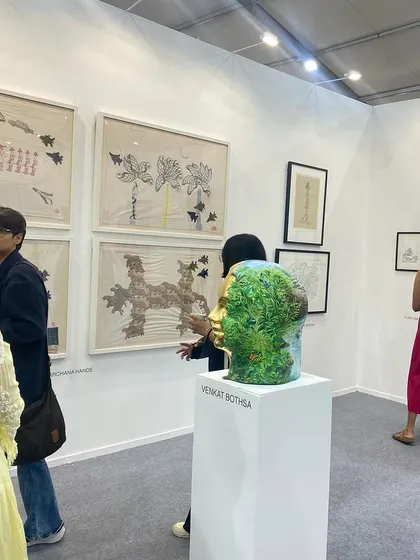 Visitors looking at the sculptures and embroidered works at our booth.