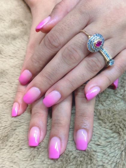 A classic pink ombre. The color smoothly transitions from a soft, natural pink at the base to a vibrant, hot pink at the tips for a timeless and feminine look.