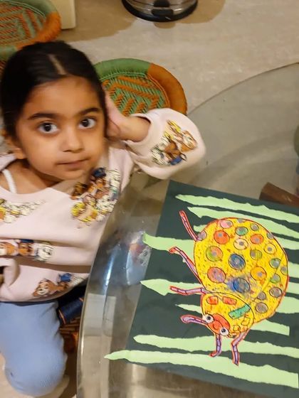 This little artist is all ears, listening to instructions while posing with her beautiful ladybug craft.