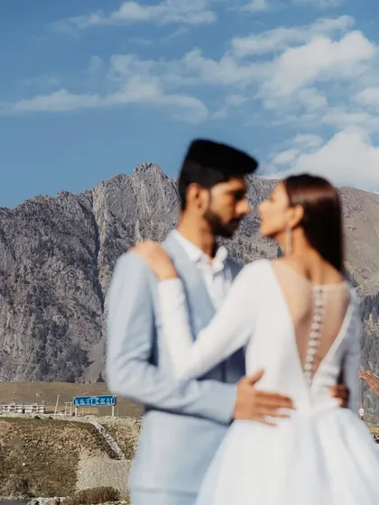 A soft-focus shot of a couple against the majestic mountains of Kashmir. This artistic photo creates a dreamy, romantic mood, emphasizing the couple's connection over the landscape.