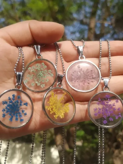 Here is another view of the Anne's lace pendants, showcasing the different colors available, including blue, yellow, and purple. These delicate flowers look like tiny starbursts suspended in resin.