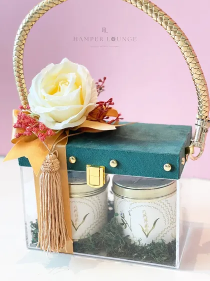 A close-up of the chic glass bag for Eid. The combination of the clear acrylic, the green suede-like top, and the golden handle makes it a modern and luxurious packaging choice.