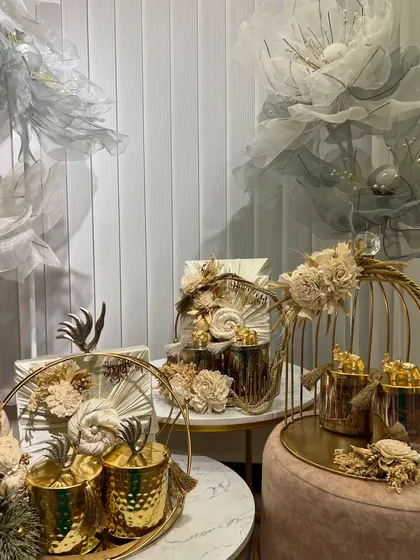 An absolutely stunning gold and white themed Rakhi collection. This is luxury gifting at its finest, with birdcage-style decor, hammered metal cups, and elegant floral arrangements.