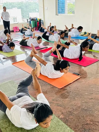 A class of dedicated students practicing Dhanurasana, or Bow Pose, together. This powerful back-strengthening pose opens the chest and energizes the entire body.