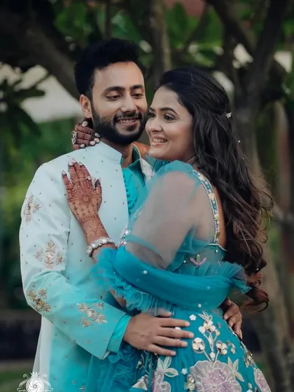 A happy couple shot from Jinal's engagement. Her blue lehenga and glowing makeup look stunning in this outdoor setting.