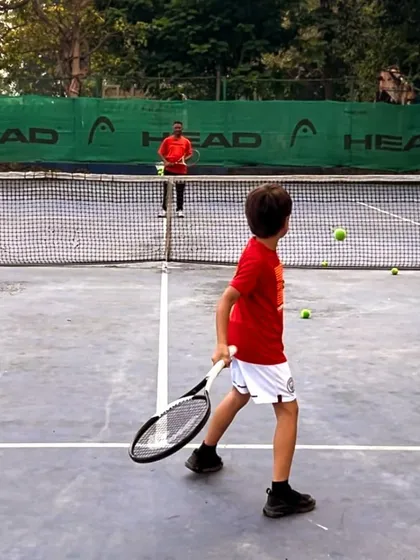 From mastering the basics to embracing brilliance, every swing is a step forward. A young player practices his returns with a coach.