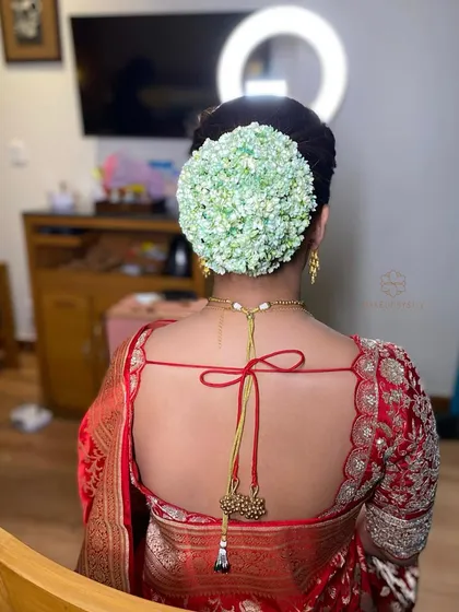 A full, lush bun made of green hydrangeas. This is a unique and modern take on the traditional floral bun, perfect for a bride who wants to make a statement.