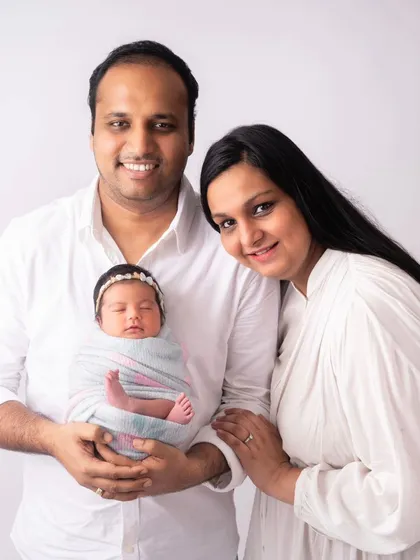 A beautiful family portrait with their newborn daughter, Jeevaa. They are all dressed in white for a clean and classic look.