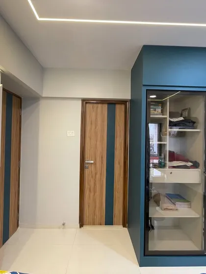 The wardrobe and door design in this room are coordinated with matching wood and blue accents for a cohesive look.
