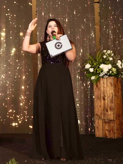 On stage with a mic in hand, ready to get the Sangeet night sparkling. The backdrop was almost as glittery as the event's vibe.