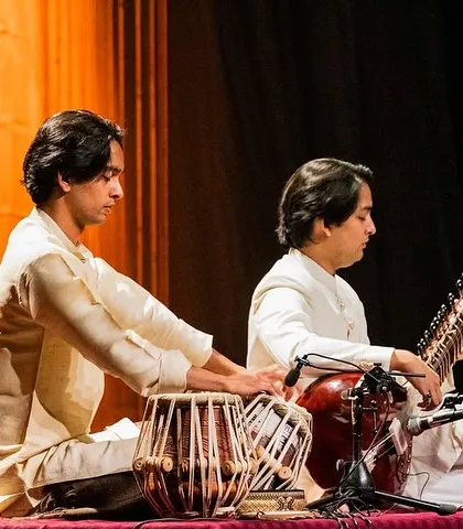 A side view of the sitar and tabla jugalbandi in Nairobi. This angle shows the intricate handwork and the dynamic interplay between the two instruments during a live classical concert.