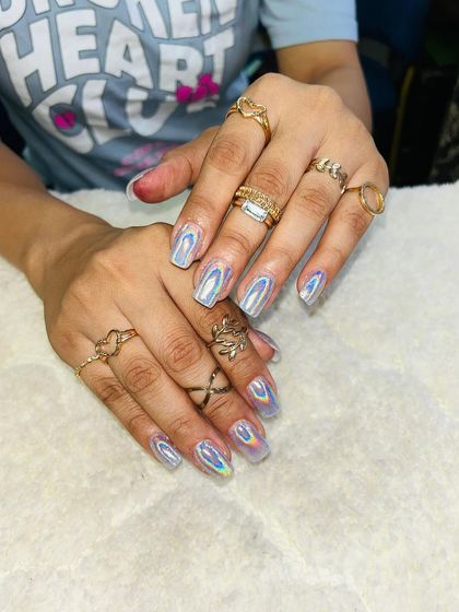 A full set of holographic silver chrome nails. The rainbow effect in the light is absolutely mesmerizing.