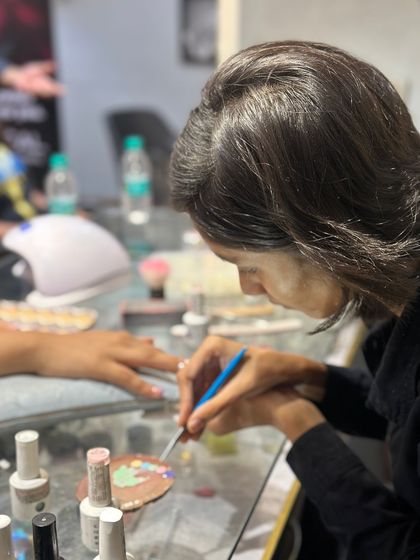 This shot shows my artist mixing custom colors on a palette. This allows us to create truly unique shades and designs tailored specifically to your preference.