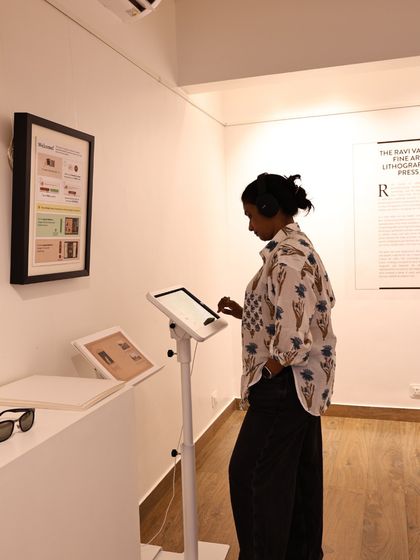 Another visitor interacts with the digital interface for the AR experience, exploring the life and work of Raja Ravi Varma in a modern, user-friendly format.