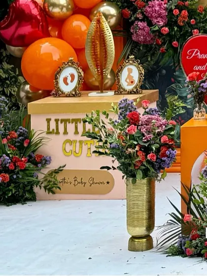 A detail shot of a personalized "Little Cutie" box and framed baby pictures.