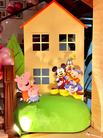 A detailed shot of the Peppa Pig house prop, with cutouts of Peppa, George, Mickey, Goofy, and Donald. This shows a fun crossover theme that delights kids with all their favorite characters.
