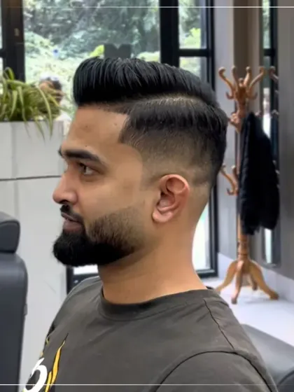 This is a high-impact look combining a sharp skin fade with a well-groomed beard. The clean lines and precise blending showcase our expertise in modern barbering and men's grooming.