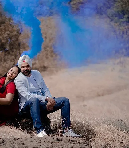 A creative shot using a blue smoke bomb to add a pop of color to the natural landscape. This adds a unique and artistic element to Karan and Simarpreet's pre-wedding session.