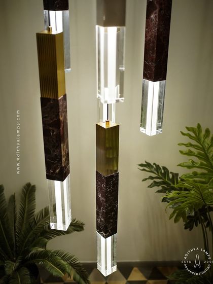 A collection of our pillar pendants, which combine sections of solid marble, fluted metal, and clear crystal. These substantial, high-quality fixtures can be hung individually or in clusters to create a dramatic effect in stairwells or entryways.