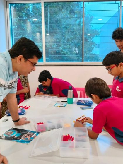 A parent at Vidyashilp Academy's project presentation event leans in to get a closer look at his son's work, sharing in the learning journey.