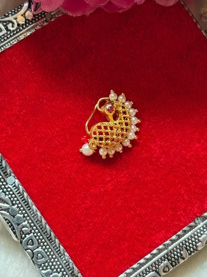 A classic peacock-style Maharashtrian Nath with delicate pearl work. This is a timeless design that complements any traditional saree.