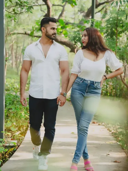 A candid shot of a couple walking and talking in a park, capturing their natural chemistry during a pre-wedding shoot.