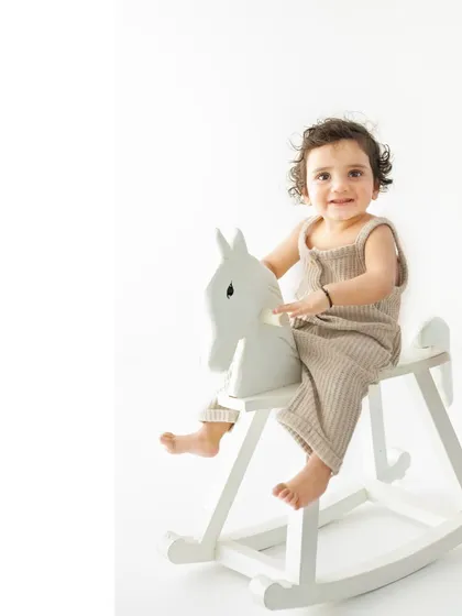 Giddy up! A classic wooden rocking horse is a perfect prop for a sitter session, encouraging playful smiles and capturing a sense of classic childhood fun in a clean, modern style.