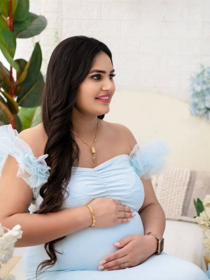 A beautiful close-up portrait capturing the radiant pregnancy glow. Her gentle smile and the soft light create an image that is both intimate and full of warmth.