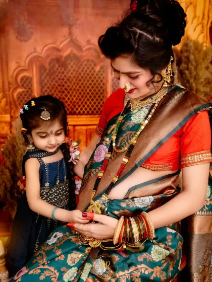 A beautiful moment of connection between a mother and her daughter. Dressed in a traditional green floral saree, the mother-to-be shares a special bond with her child, highlighting our expertise in ethnic maternity photography.