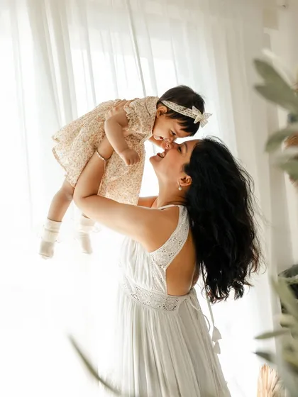 A mother's joy, lifting her world high. I love capturing these spontaneous, light-filled moments of connection that show the pure happiness a child brings into your life. This is a perfect memory from a first birthday photoshoot.