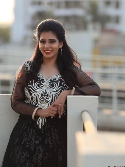 A relaxed and confident portrait taken on a balcony during the golden hour. The light is perfect for creating a warm and inviting mood.