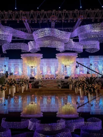 The full view of the crystal wonderland reception, with the stage and ceiling installations lit in a beautiful purple hue. The reflection on the glossy floor doubles the impact of the design.