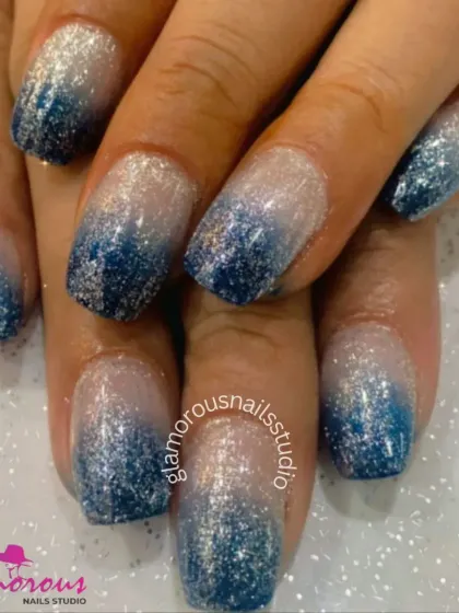 A beautiful glitter ombré design, fading from a dense, sparkling blue at the tips to a sheer, shimmery base.