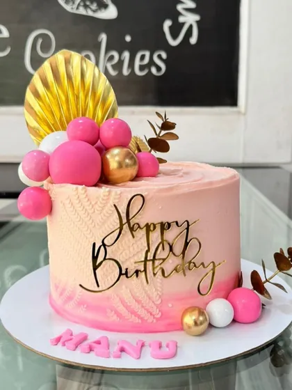 A lovely pink birthday cake for Manu, featuring a knitted texture effect, spheres, and a gold palm spear.