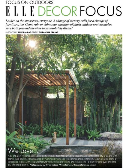 A feature in Elle Decor magazine showcasing the outdoor space at KEUS, described as "a bit of Bali in Hyderabad." The image captures a tranquil pergola and seating area surrounded by lush greenery.