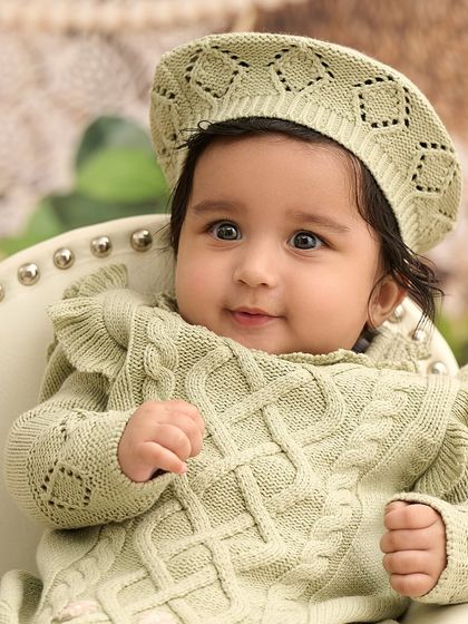 A beautiful close-up of a baby girl in a knitted outfit. We focus on capturing the delicate features and sweet expressions of your little one.